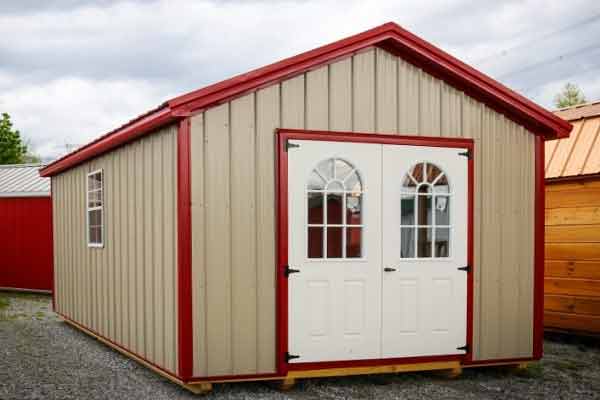 Tan a-frame shed with dark red trim