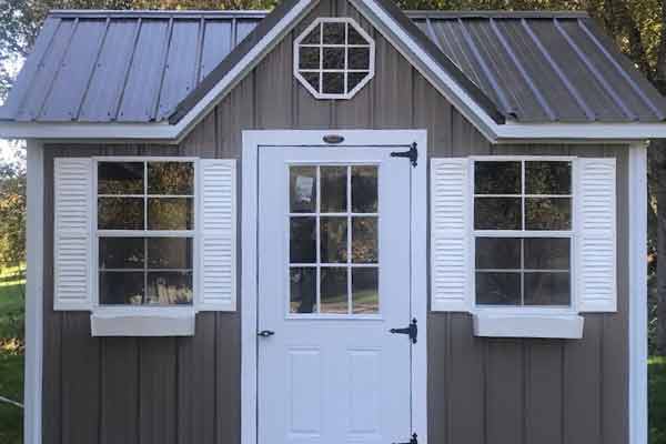 Small metal shed with shutters, window boxes, and more architectural details